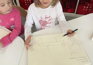 dzieci rysują historię głoski "o" w dedykowanych książkach